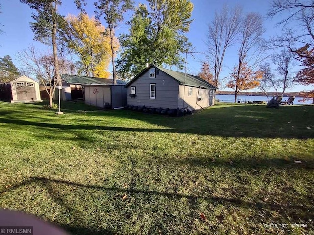 1219 Shore Dr, Luck, WI 54853 - view of green lawn with a shed, an outbuilding, and a water view