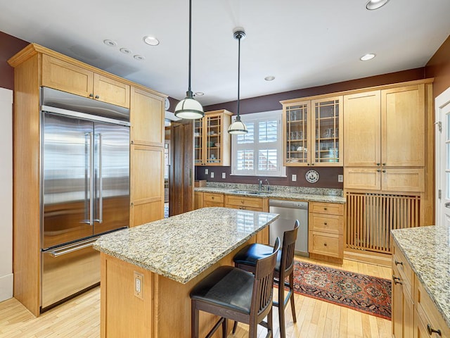760 Linwood Ave, Saint Paul, MN 55105 - kitchen featuring appliances with stainless steel finishes, a sink, light wood finished floors, light stone counters, and glass insert cabinets