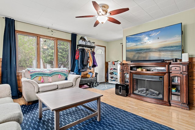 living area featuring ceiling fan, wood finished floors, and a fireplace