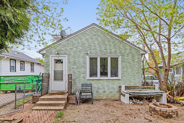 back of house featuring fence and a fire pit
