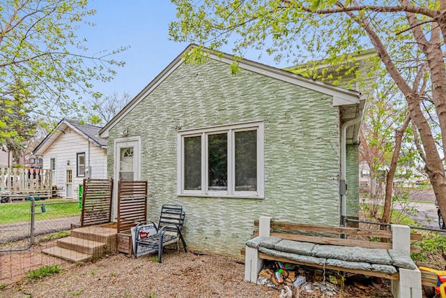 view of home's exterior with fence and stone siding