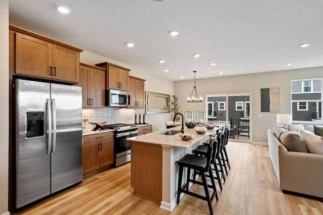 6758 Wildflower Way, Minnetrista, MN 55331 - kitchen with stainless steel appliances, a sink, brown cabinetry, backsplash, and recessed lighting