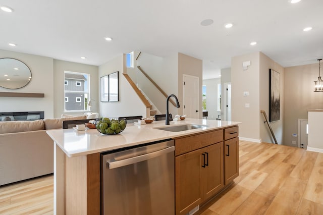 6758 Wildflower Way, Minnetrista, MN 55331 - kitchen with dishwasher, a sink, open floor plan, light wood-style flooring, and a kitchen island with sink