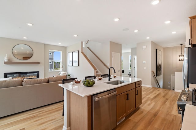 6758 Wildflower Way, Minnetrista, MN 55331 - kitchen with stainless steel appliances, a sink, open floor plan, light wood-style floors, and recessed lighting