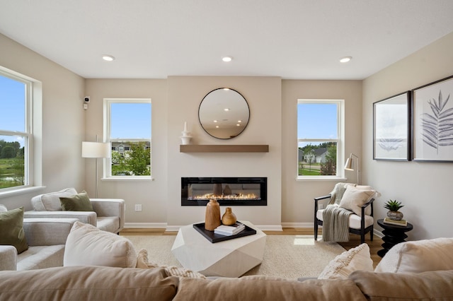 6758 Wildflower Way, Minnetrista, MN 55331 - living area with a glass covered fireplace, healthy amount of natural light, recessed lighting, baseboards, and light wood finished floors