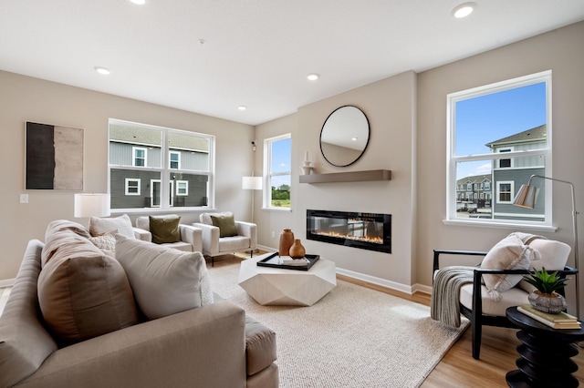 6758 Wildflower Way, Minnetrista, MN 55331 - living room with light wood finished floors, a glass covered fireplace, baseboards, and recessed lighting