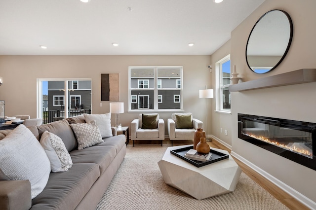 6758 Wildflower Way, Minnetrista, MN 55331 - living area featuring wood finished floors, recessed lighting, a glass covered fireplace, and baseboards