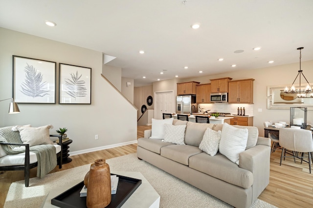 6758 Wildflower Way, Minnetrista, MN 55331 - living area featuring a chandelier, stairway, light wood-style flooring, baseboards, and recessed lighting
