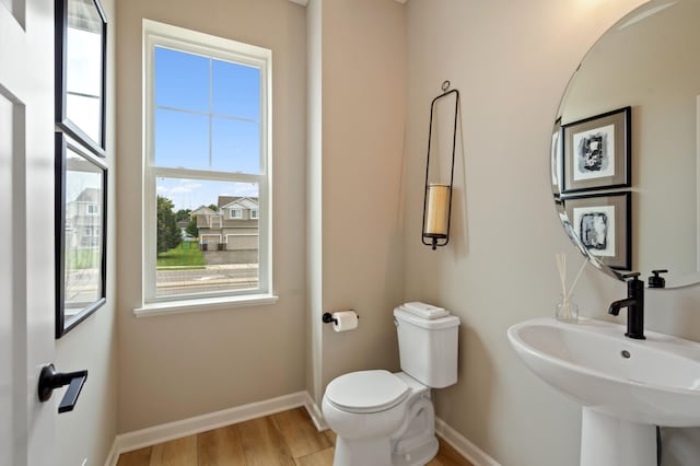 6758 Wildflower Way, Minnetrista, MN 55331 - bathroom with baseboards, a sink, toilet, and wood finished floors
