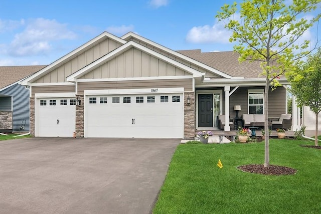 craftsman-style home featuring board and batten siding, driveway, a front lawn, a garage, and a shingled roof