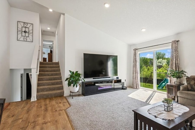 living room with lofted ceiling, recessed lighting, stairs, and wood finished floors