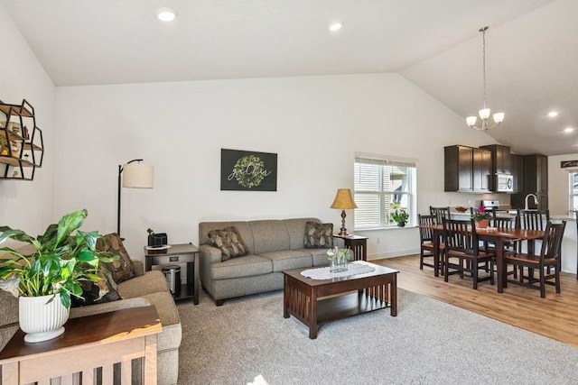 living room with light wood finished floors, recessed lighting, a chandelier, baseboards, and high vaulted ceiling