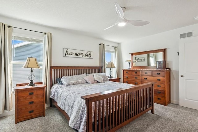 bedroom featuring light carpet and a ceiling fan
