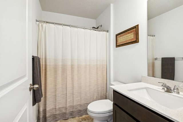 bathroom featuring toilet, vanity, and curtained shower