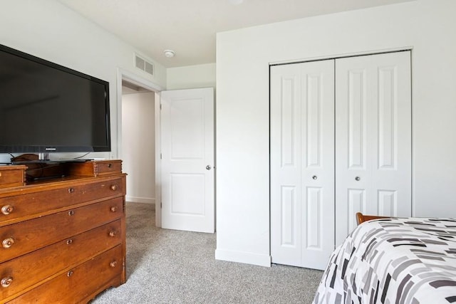 bedroom featuring light carpet, a closet, and baseboards