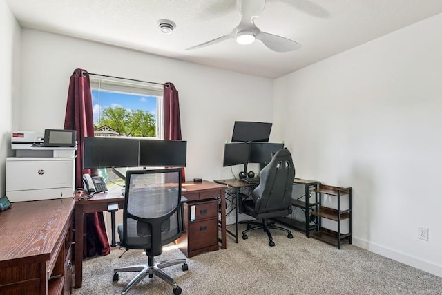 carpeted office with a ceiling fan and baseboards