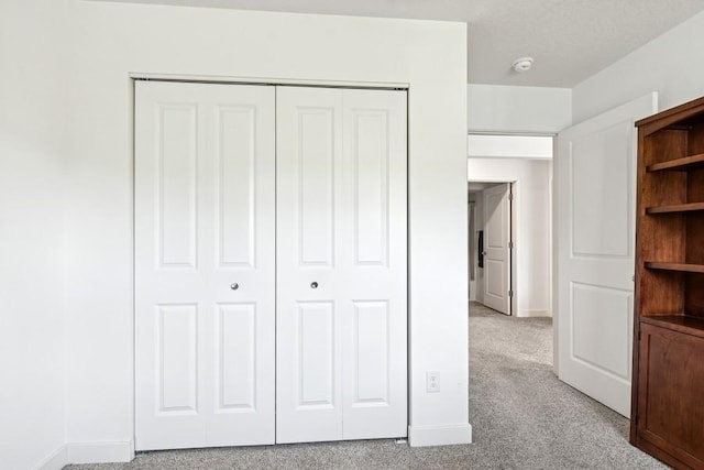 unfurnished bedroom featuring a closet, baseboards, and carpet