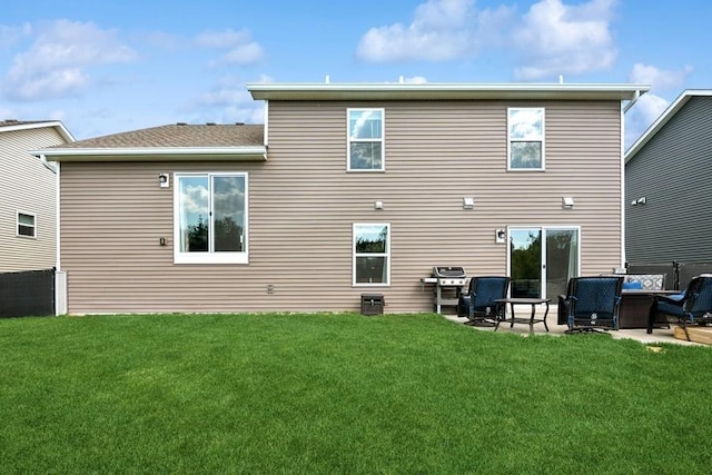 rear view of property with a yard and a patio