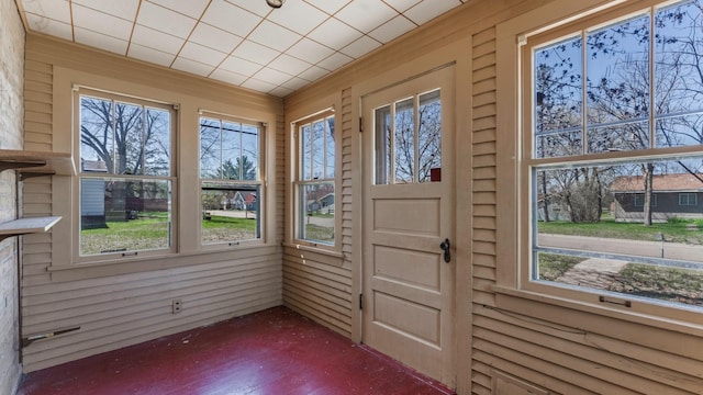 doorway to outside with wood walls