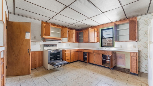 kitchen featuring light countertops, open shelves, stove, and wallpapered walls