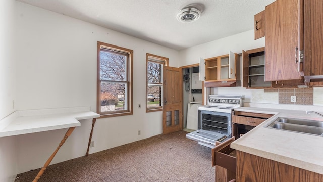kitchen with a sink, brown cabinetry, carpet flooring, and open shelves