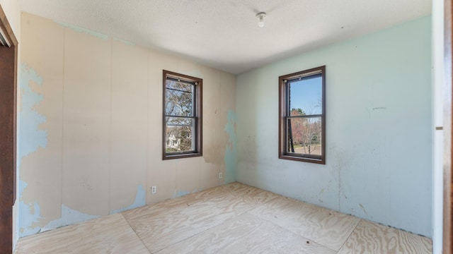 unfurnished room featuring a textured ceiling