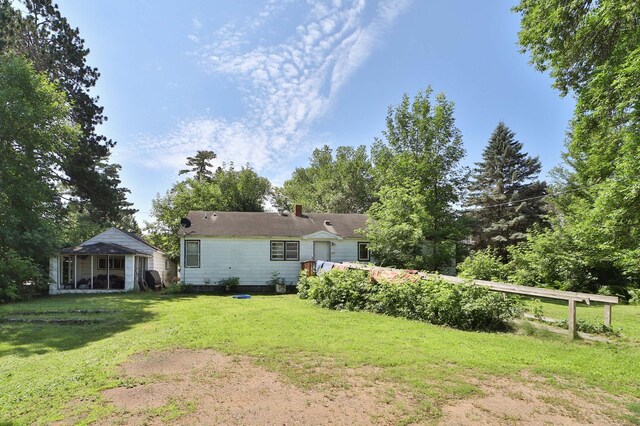203 Main St, Crosby, MN 56441 - back of property featuring a lawn, a chimney, and a sunroom