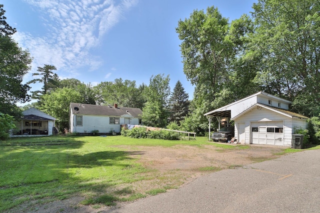 203 Main St, Crosby, MN 56441 - view of grassy yard with a garage, an outdoor structure, driveway, and view of scattered trees