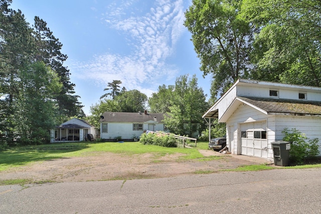 203 Main St, Crosby, MN 56441 - view of side of home featuring a garage, dirt driveway, and a lawn