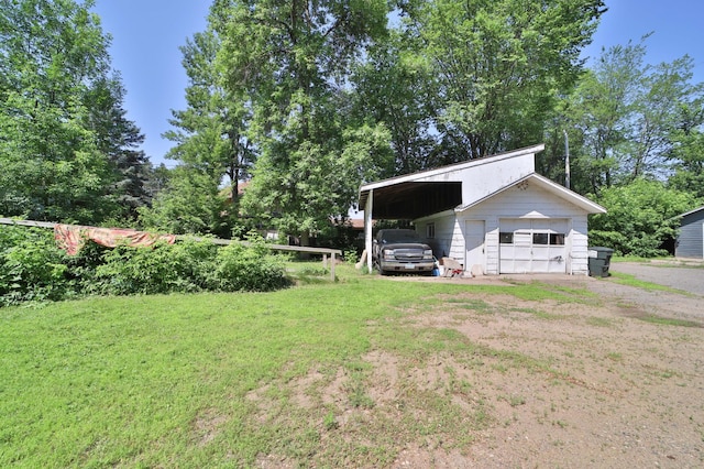 203 Main St, Crosby, MN 56441 - view of green lawn featuring dirt driveway, a detached garage, an outbuilding, and view of wooded area