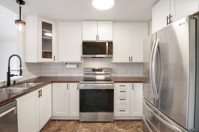 kitchen featuring a sink, stainless steel appliances, white cabinetry, and marble finish floor
