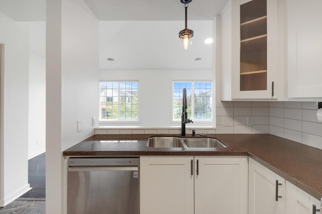 kitchen with glass insert cabinets, white cabinets, tasteful backsplash, a sink, and dishwasher