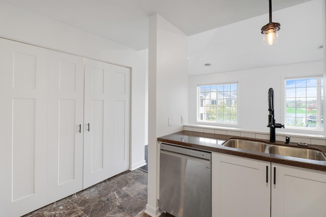 kitchen featuring dark countertops, dishwasher, a sink, white cabinets, and marble finish floor