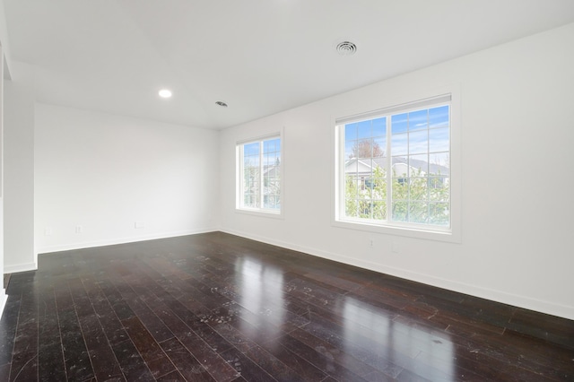 empty room with baseboards, wood-type flooring, and recessed lighting