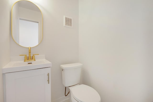 bathroom featuring baseboards, visible vents, toilet, and vanity