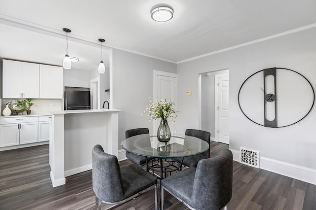 dining space featuring crown molding, baseboards, dark wood-style floors, and visible vents