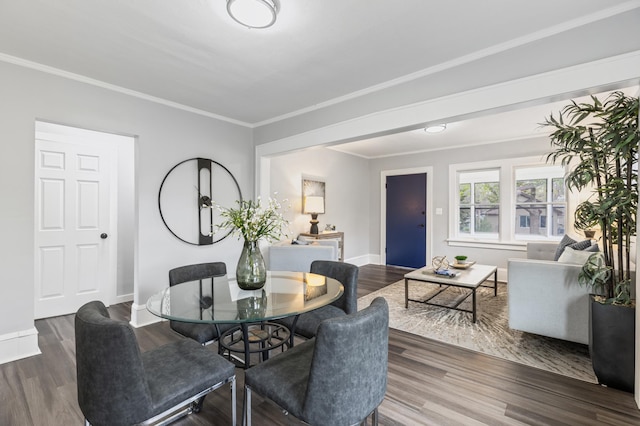 dining room with crown molding, baseboards, and wood finished floors