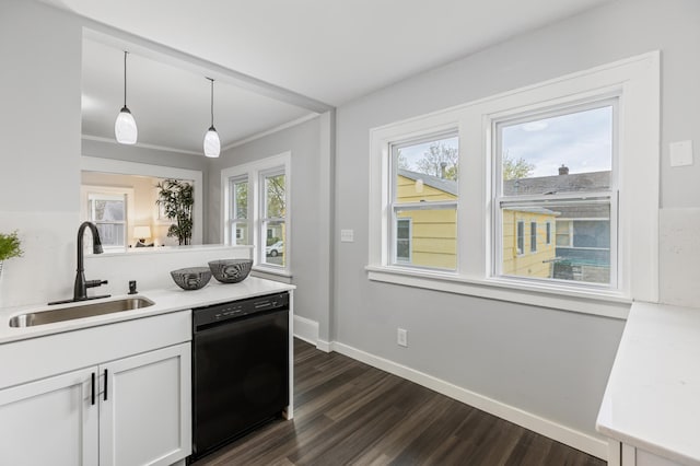 kitchen featuring pendant lighting, black dishwasher, white cabinets, a sink, and dark wood finished floors