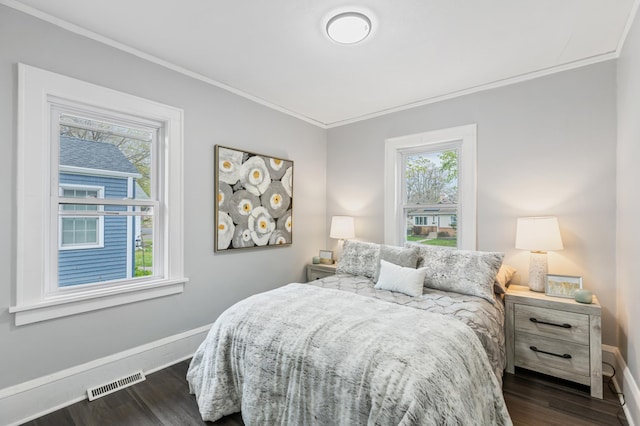 bedroom with visible vents, baseboards, crown molding, and dark wood finished floors