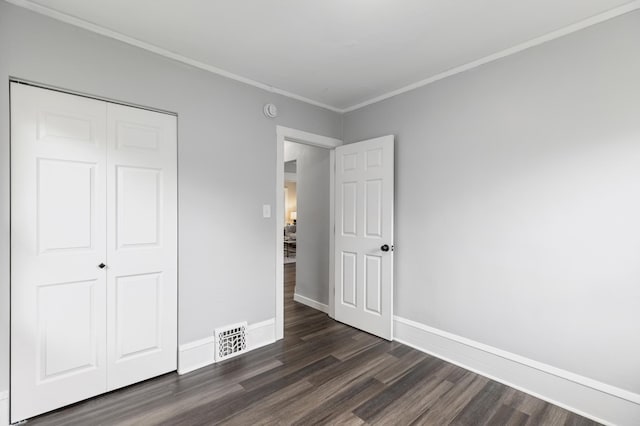 unfurnished bedroom featuring crown molding, baseboards, dark wood-style floors, and visible vents