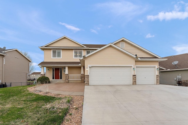 craftsman-style home featuring fence, a front yard, concrete driveway, an attached garage, and a porch