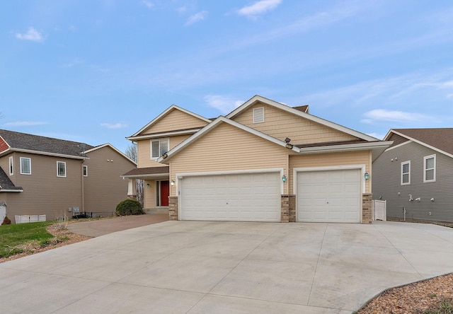 craftsman inspired home featuring a garage, driveway, and stone siding