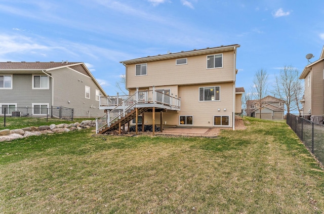 back of property featuring a fenced backyard, a wooden deck, a lawn, and stairway
