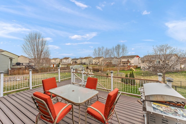 deck with a fenced backyard, area for grilling, a lawn, a residential view, and outdoor dining space