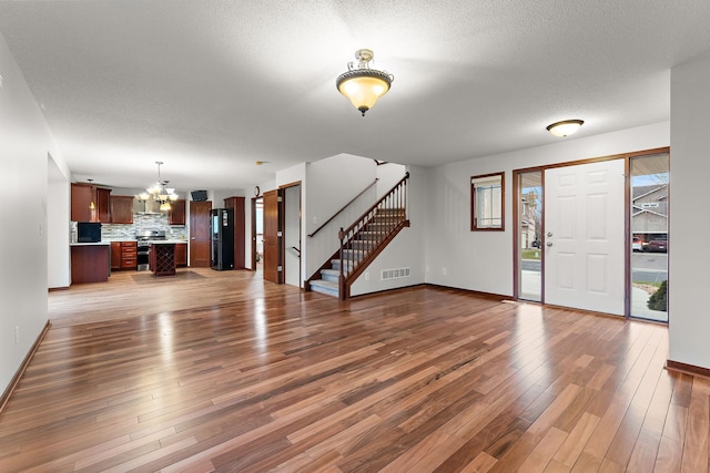 foyer entrance featuring an inviting chandelier, baseboards, and visible vents