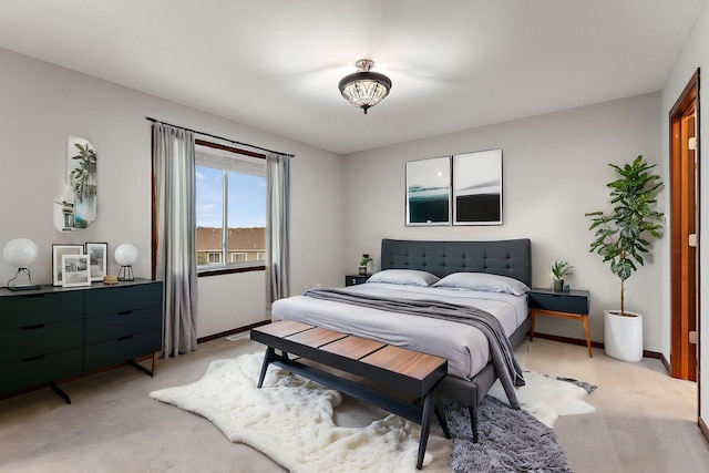 bedroom with light colored carpet and baseboards