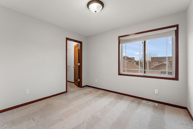 empty room with visible vents, carpet flooring, and baseboards