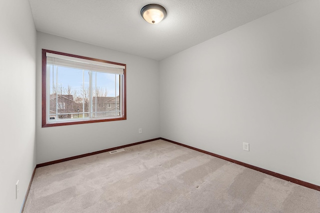 carpeted empty room with visible vents and baseboards