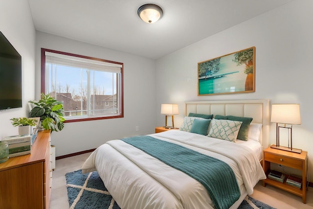 bedroom with baseboards and light carpet