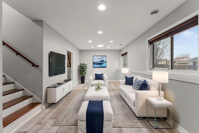 living area with recessed lighting, baseboards, and light wood-type flooring
